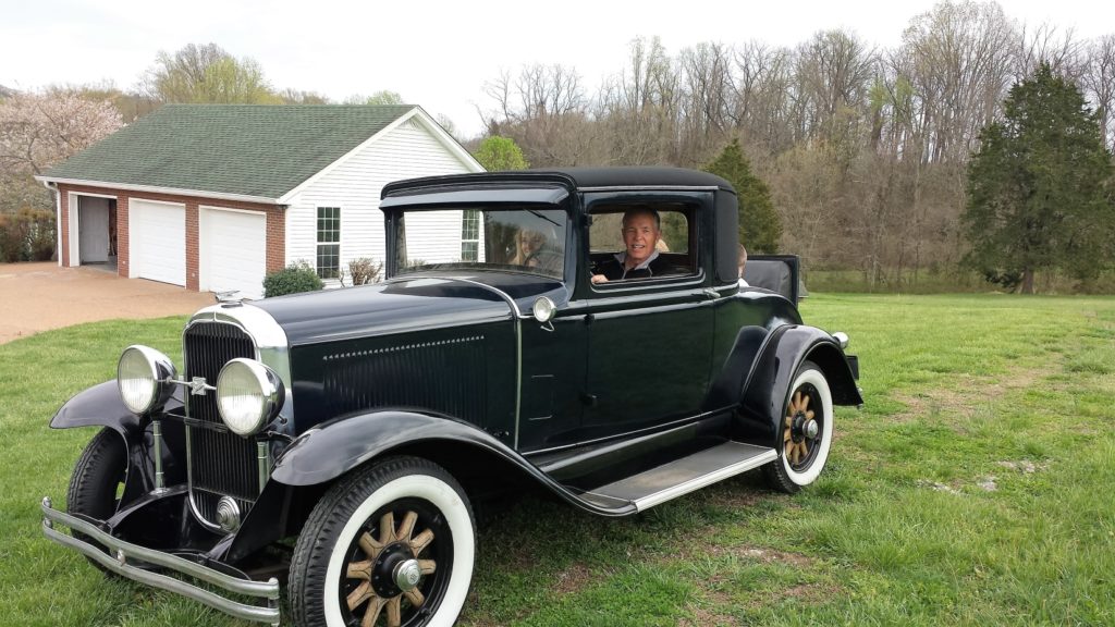 Guy taking the grand kids for a ride in his '31 Buick